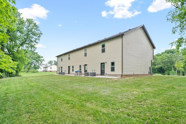 rear view of house featuring a lawn, a patio area, and central AC