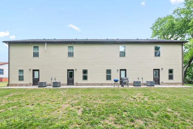 rear view of property featuring a yard and central AC unit