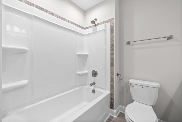 bathroom with hardwood / wood-style floors, toilet, and bathtub / shower combination