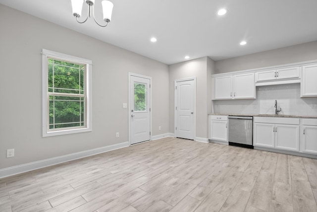 kitchen with dishwasher, decorative backsplash, and white cabinets