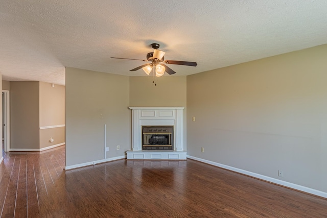 unfurnished living room with ceiling fan, dark hardwood / wood-style floors, and a textured ceiling