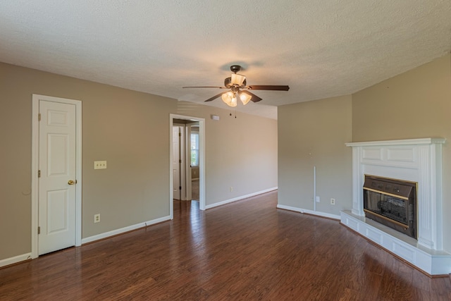 unfurnished living room with ceiling fan, dark wood-type flooring, and a textured ceiling