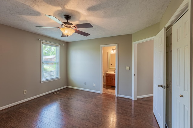 unfurnished bedroom with a textured ceiling, ceiling fan, and dark wood-type flooring