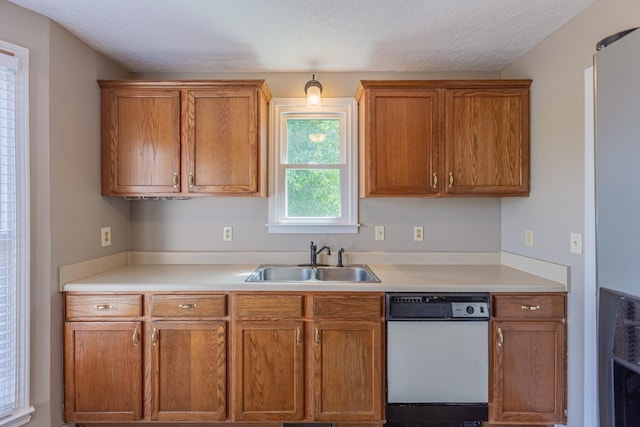 kitchen featuring a textured ceiling, white dishwasher, heating unit, and sink