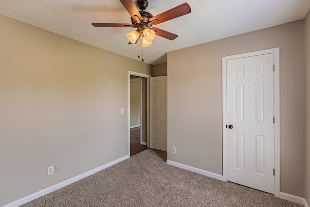 unfurnished bedroom featuring ceiling fan, carpet, and a textured ceiling