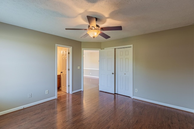 unfurnished bedroom featuring ceiling fan, a closet, dark hardwood / wood-style floors, and a textured ceiling