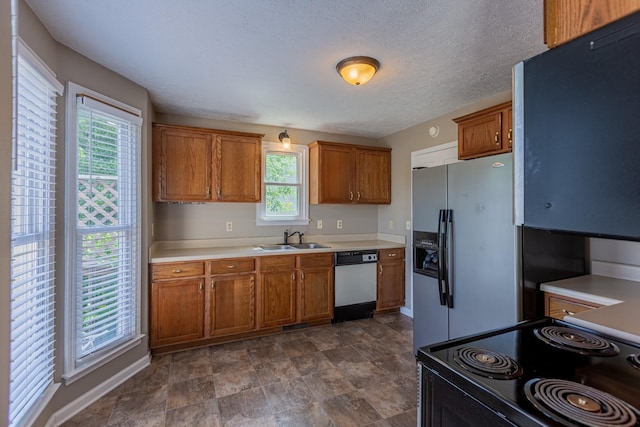 kitchen featuring sink, a textured ceiling, and stainless steel appliances