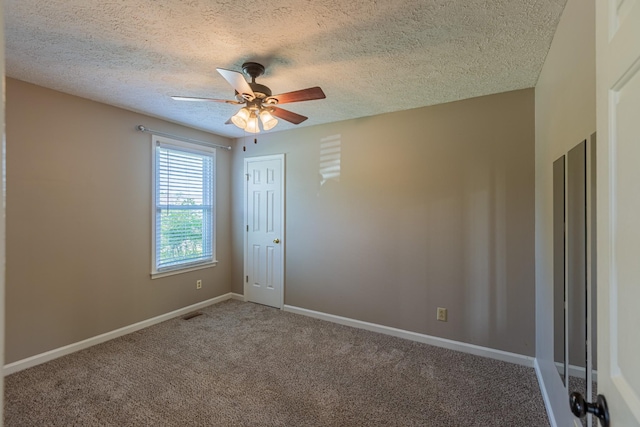 unfurnished room with a textured ceiling and carpet flooring