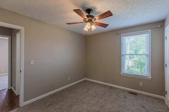 carpeted empty room featuring ceiling fan and a textured ceiling