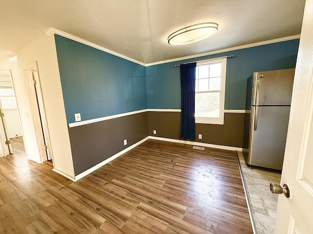 unfurnished dining area with hardwood / wood-style flooring and crown molding