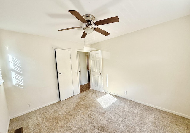 unfurnished bedroom featuring ceiling fan and light colored carpet