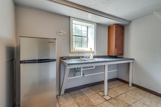 kitchen featuring stainless steel fridge and sink