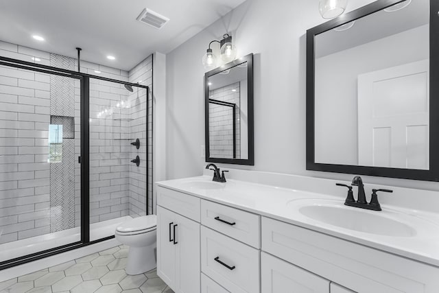 bathroom with toilet, vanity, tile patterned floors, and a shower with door