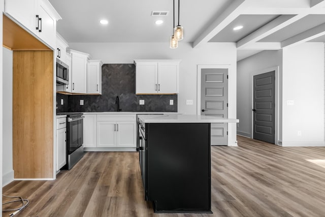 kitchen with stainless steel appliances, backsplash, pendant lighting, white cabinets, and a center island