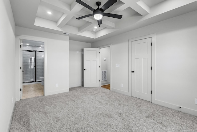 unfurnished bedroom featuring beam ceiling, light colored carpet, coffered ceiling, and connected bathroom