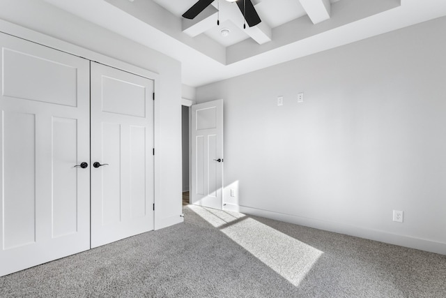 bedroom featuring ceiling fan, carpet, a closet, and beamed ceiling