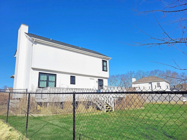 back of property featuring a yard, a chimney, and fence