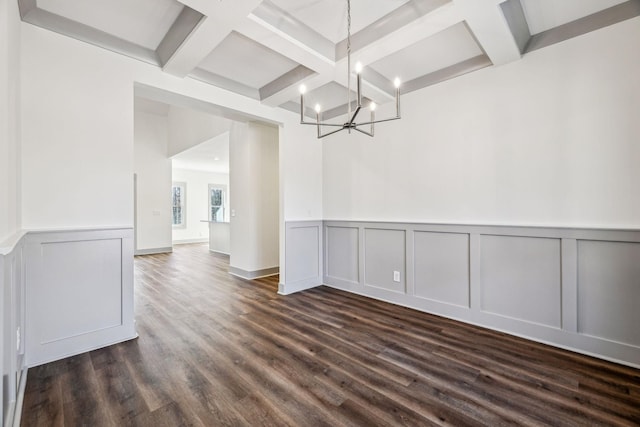 unfurnished dining area featuring beamed ceiling, an inviting chandelier, dark wood-type flooring, and coffered ceiling