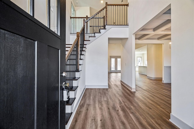 foyer with beamed ceiling, a high ceiling, hardwood / wood-style flooring, and coffered ceiling