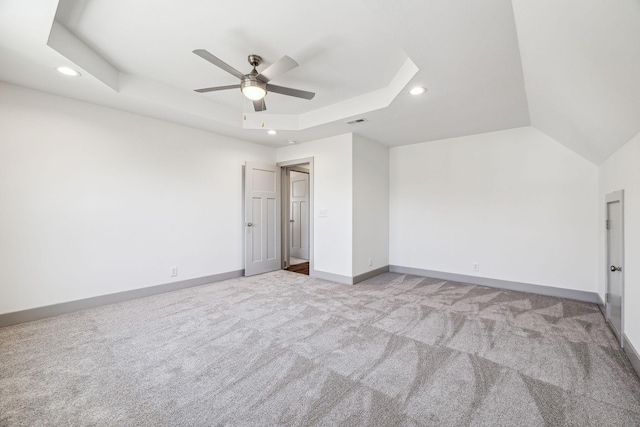 unfurnished bedroom featuring a tray ceiling, ceiling fan, and light colored carpet