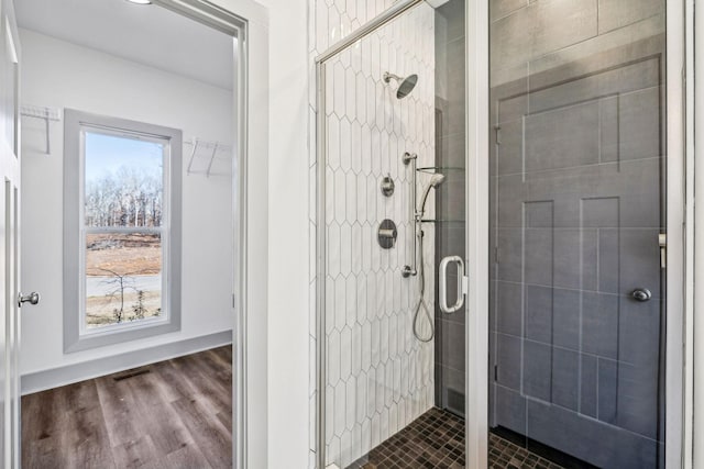 bathroom featuring a healthy amount of sunlight, an enclosed shower, and wood-type flooring