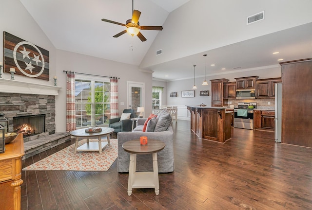 living room featuring ceiling fan, dark hardwood / wood-style flooring, a fireplace, and high vaulted ceiling