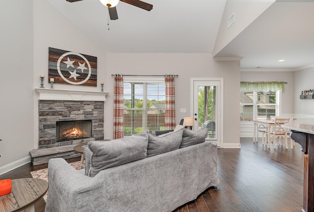 living room with ceiling fan, a stone fireplace, lofted ceiling, and dark wood-type flooring