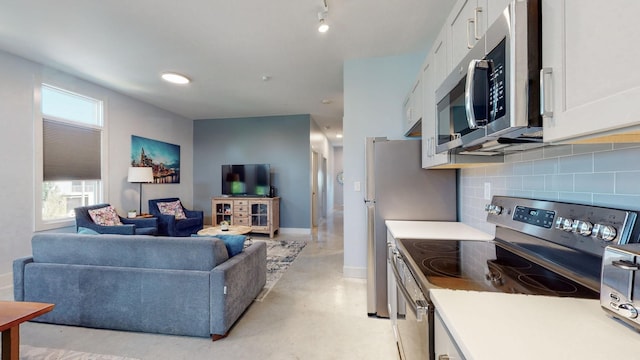 kitchen with backsplash, white cabinetry, and stainless steel appliances