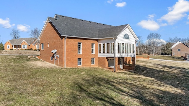 rear view of house with a sunroom and a lawn