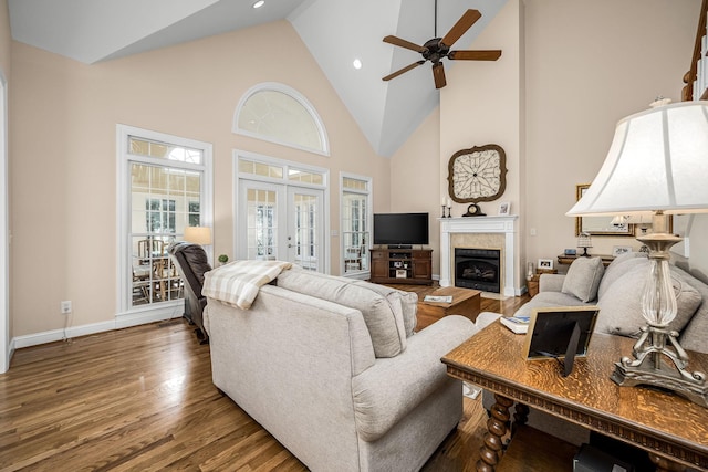 living room with dark hardwood / wood-style flooring, ceiling fan, high vaulted ceiling, and french doors