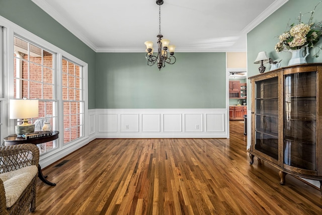 dining space with a wealth of natural light, crown molding, an inviting chandelier, and dark hardwood / wood-style flooring