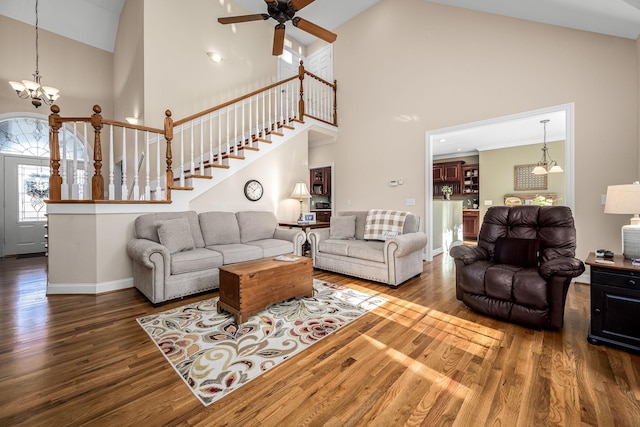 living room featuring ceiling fan with notable chandelier, wood-type flooring, and high vaulted ceiling