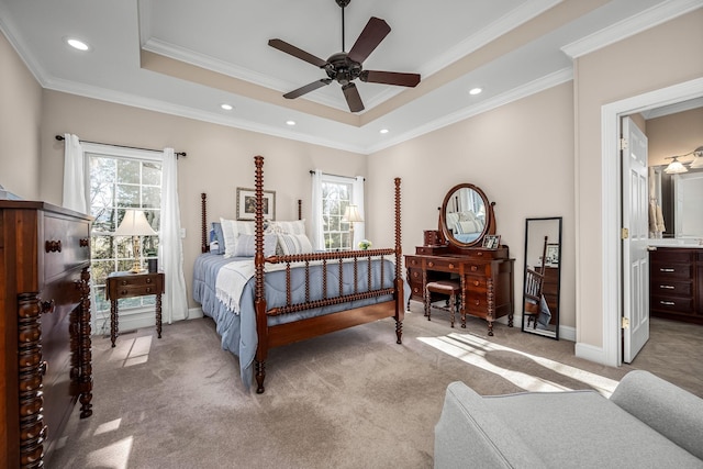 bedroom featuring multiple windows, a raised ceiling, ceiling fan, and ensuite bathroom