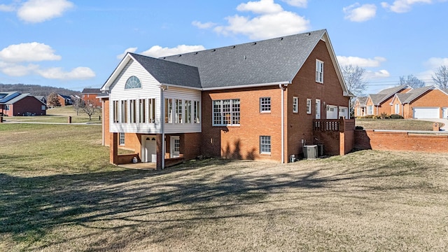 back of house with a sunroom, a yard, and central AC unit