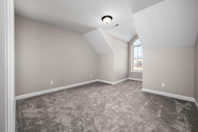 bonus room with vaulted ceiling and carpet floors