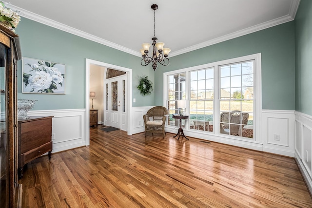 unfurnished room with crown molding, wood-type flooring, and a chandelier