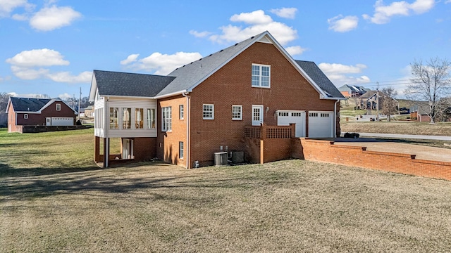 view of property exterior with central AC unit, a garage, a lawn, and a sunroom