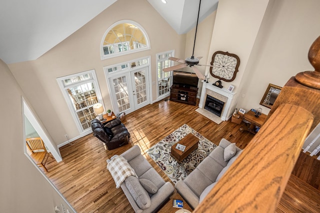 living room featuring ceiling fan, hardwood / wood-style floors, high vaulted ceiling, and french doors