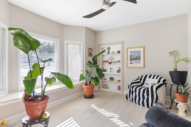 living area with ceiling fan and light hardwood / wood-style floors