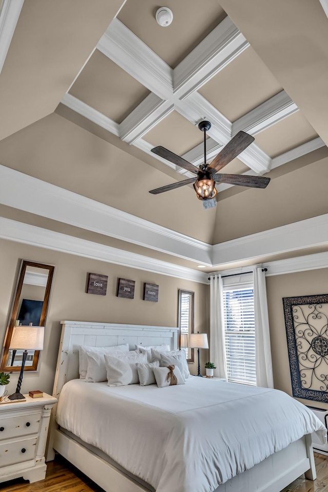 bedroom with ceiling fan, crown molding, wood-type flooring, and coffered ceiling