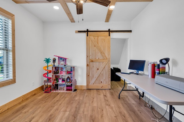 office space featuring wood-type flooring, a barn door, plenty of natural light, and ceiling fan