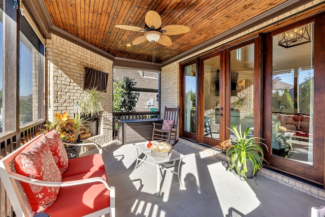 sunroom with ceiling fan, a healthy amount of sunlight, and wooden ceiling