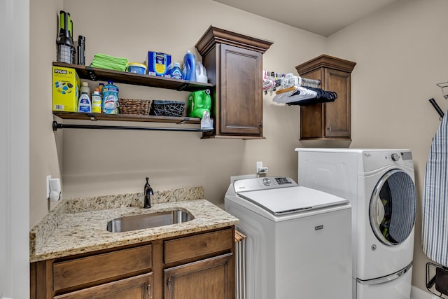 laundry area with cabinets, separate washer and dryer, and sink