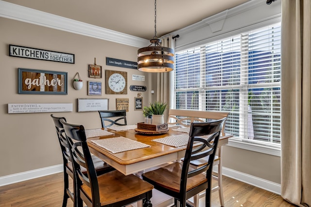 dining space featuring hardwood / wood-style flooring, a chandelier, and ornamental molding