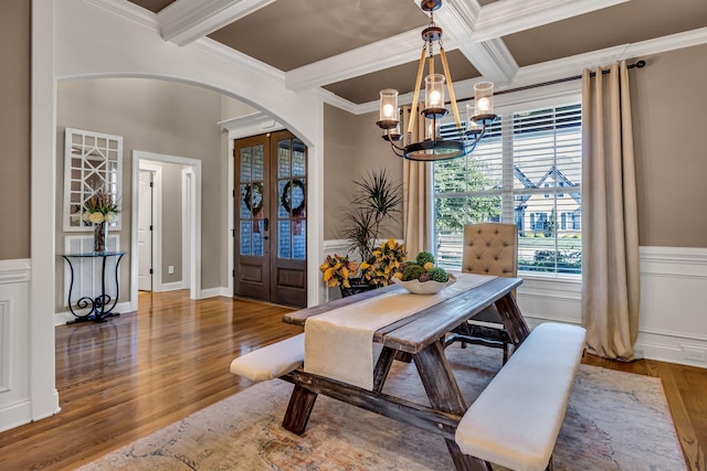 dining area featuring crown molding, beamed ceiling, coffered ceiling, and hardwood / wood-style flooring