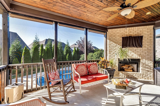 sunroom / solarium with ceiling fan, a healthy amount of sunlight, and wooden ceiling