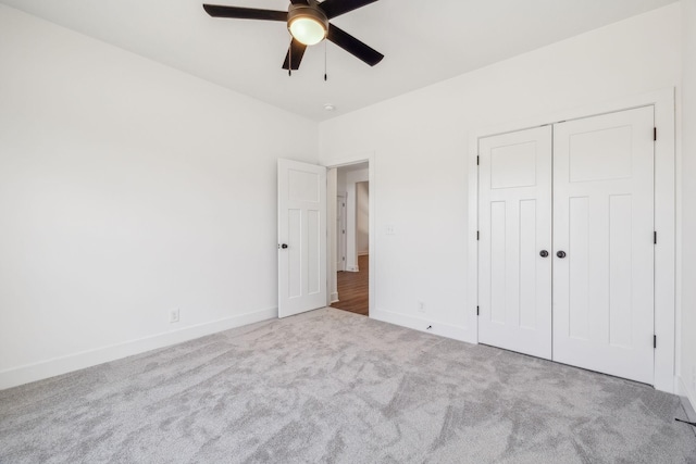 unfurnished bedroom with ceiling fan, light carpet, and a closet