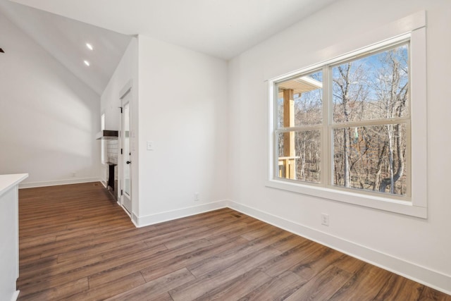 unfurnished dining area featuring vaulted ceiling and hardwood / wood-style flooring