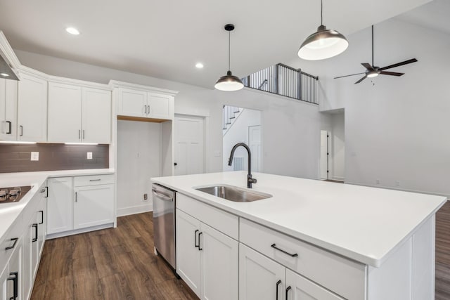 kitchen with ceiling fan, sink, stainless steel dishwasher, a kitchen island with sink, and white cabinets