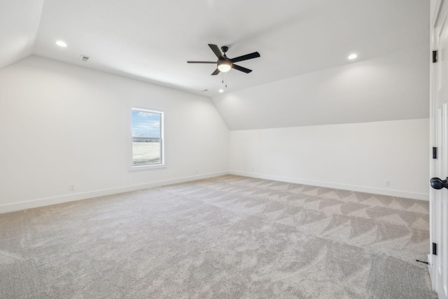 additional living space with light colored carpet, ceiling fan, and lofted ceiling